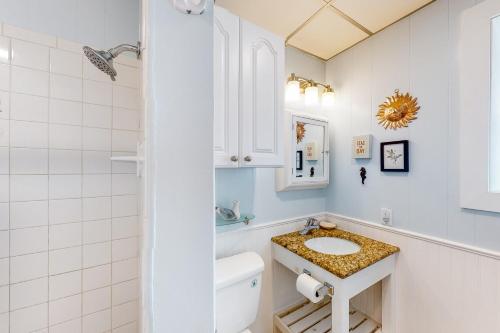 een witte badkamer met een wastafel en een toilet bij Seaside Pearl in Mustang Beach