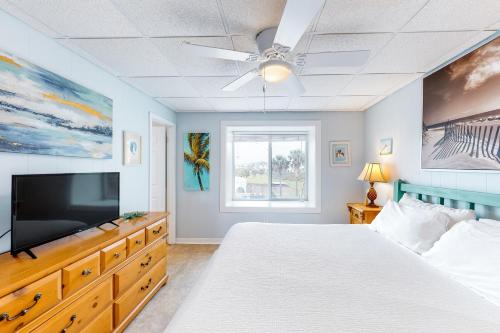 a bedroom with a bed and a flat screen tv at Seaside Pearl in Mustang Beach