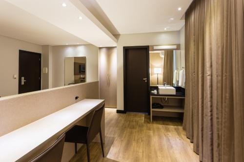 a bathroom with a sink and a mirror at Faial Prime Suítes in Florianópolis