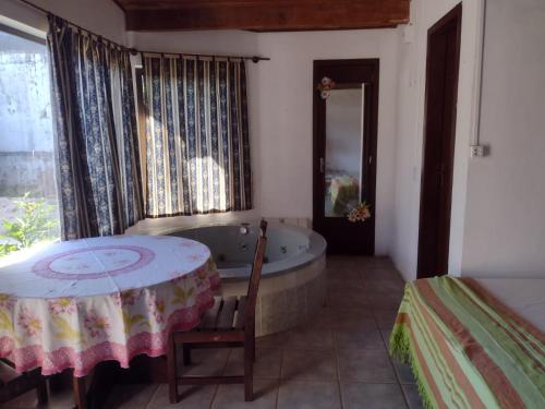 Pokój z wanną, stołem i łóżkiem w obiekcie Scotti's Suítes w mieście Capão da Canoa