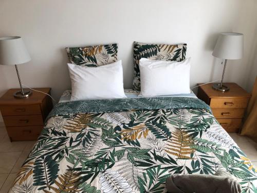 um quarto com uma cama com um edredão verde e branco em Ocean Dream Apartment no Funchal