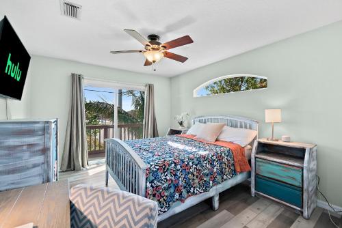 メルボルンにあるCoconut Cabana - Duplex Delight, Beach-Themed 6BR Retreat with 2 Outdoor Patios & GRILL, Steps from the Sand!のベッドと天井扇風機のある寝室