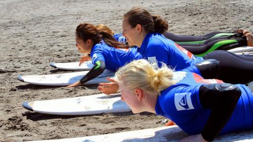 a group of women laying on surfboards on the beach at Departamento Full 3D 2B Cerca de Playas en Arica in Arica