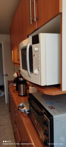 a microwave sitting on top of a kitchen counter at Departamento Full 3D 2B Cerca de Playas en Arica in Arica