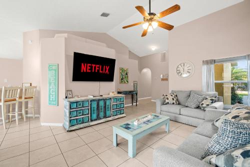 a living room with a tv on a wall at Sunset Serenity - 3BR Beach Townhome with outdoor patio - NEW HOT TUB, Steps to Ocean Fun! in Melbourne