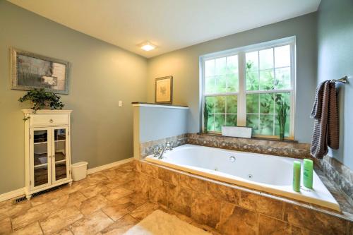 a large bathroom with a tub and a window at Hot Tub and Wooded Views Lakefront Blue Eye Cottage in Blue Eye