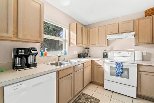 a kitchen with wooden cabinets and white appliances at Sunset Serenity - 3BR Beach Townhome with outdoor patio - NEW HOT TUB, Steps to Ocean Fun! in Melbourne