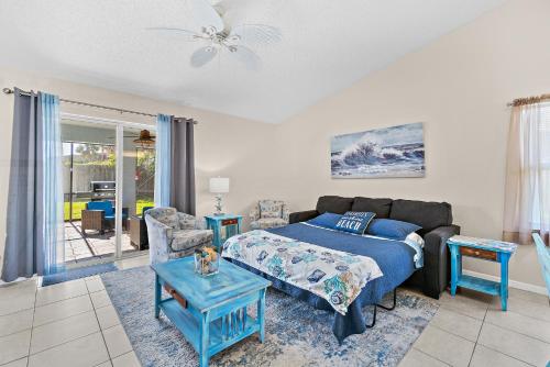 a living room with a bed and a couch at Serene Seaside Retreat - Dog friendly - 2BR Townhouse with Heated Pool Steps to Paradise Beach! in Melbourne