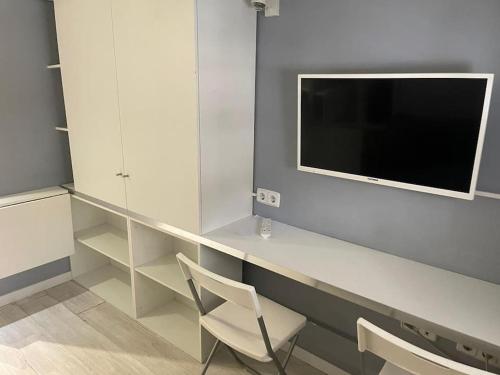 Cette chambre dispose d'un bureau, d'une télévision et d'une chaise. dans l'établissement Lovely Loft Bernabéu Madrid, à Madrid