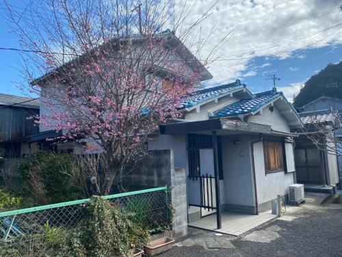 a house with a flowering tree in front of it at boschetto - Vacation STAY 05407v in Kami-ichi
