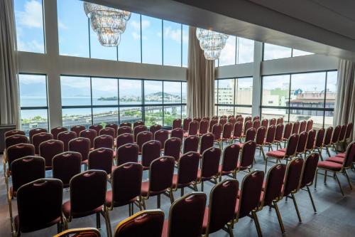 a conference room with chairs and large windows at Faial Prime Suítes in Florianópolis