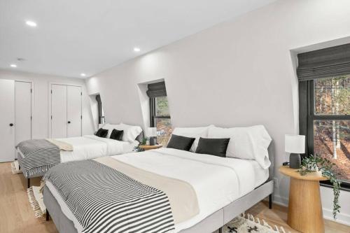 two beds in a bedroom with white walls and windows at Pine Hill Chateau - Ski Belleayre, Hunter Mountain in Pine Hill