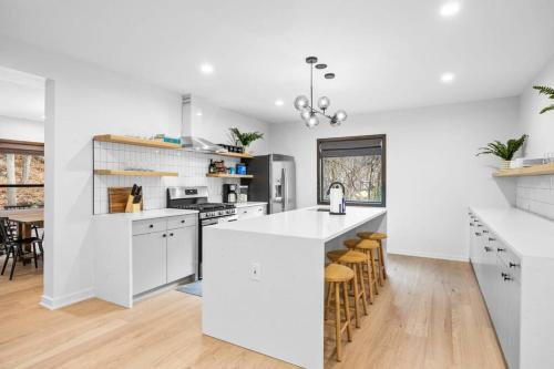 a kitchen with white cabinets and a kitchen island with bar stools at Pine Hill Chateau - Ski Belleayre, Hunter Mountain in Pine Hill