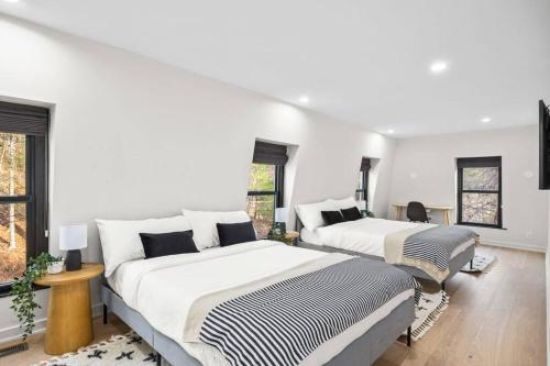 two beds in a room with white walls and windows at Pine Hill Chateau - Ski Belleayre, Hunter Mountain in Pine Hill