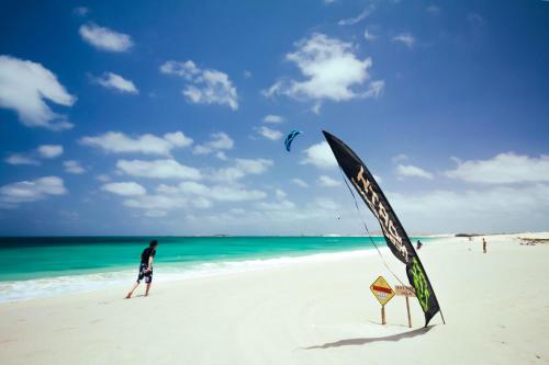 a man is flying a kite on the beach at Aparthotel Por do Sol in Sal Rei
