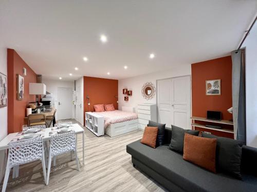 een woonkamer met een bank en een bed bij L'Orangeraie in Brioude