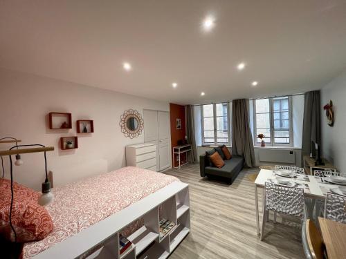 a bedroom with a bed and a living room at L'Orangeraie in Brioude