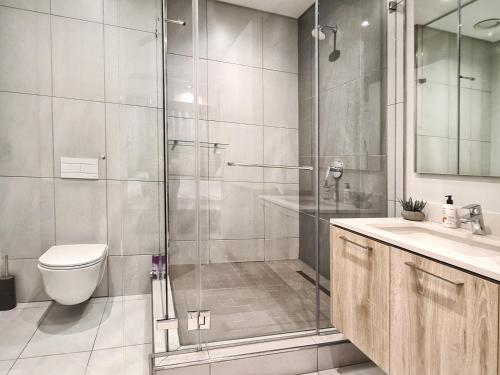 a bathroom with a shower and a toilet and a sink at 11 Floors in the Sky - Luxurious 1 Bedroom in Pretoria