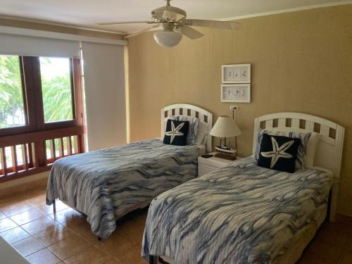 a bedroom with two beds and a ceiling fan at Bahia Pez Vela Resort in Ocotal