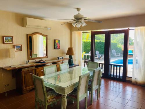 a dining room with a glass table and chairs at Bahia Pez Vela Resort in Ocotal