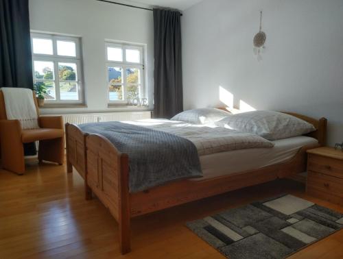 Schlafzimmer mit einem Bett, einem Stuhl und Fenstern in der Unterkunft Appartement DOM II - Erfurt Domplatz in Erfurt