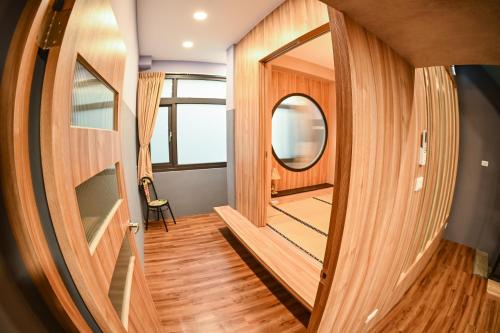 a room with wooden floors and a round mirror at Yonghua 196 in Tainan