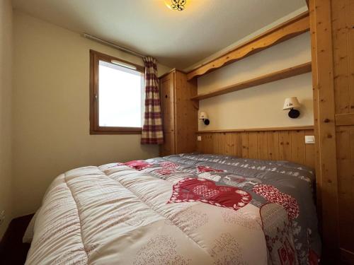 a bed in a room with a window at Appartement Lanslebourg-Mont-Cenis, 3 pièces, 6 personnes - FR-1-508-256 in Lanslebourg-Mont-Cenis