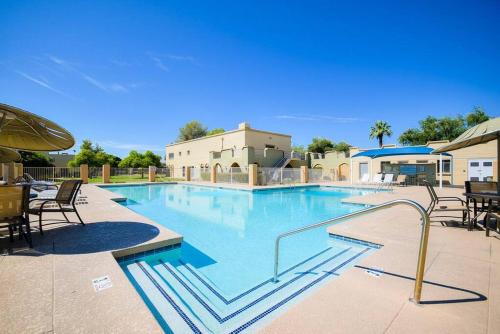a large swimming pool with tables and chairs at The Easy of Old Town in Scottsdale