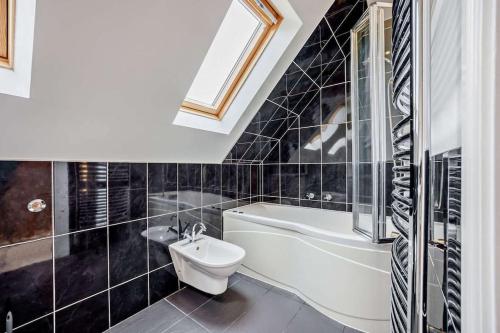 a bathroom with a tub and a toilet and a sink at Beautiful 4-5 bedroom village house with rural views in Salford