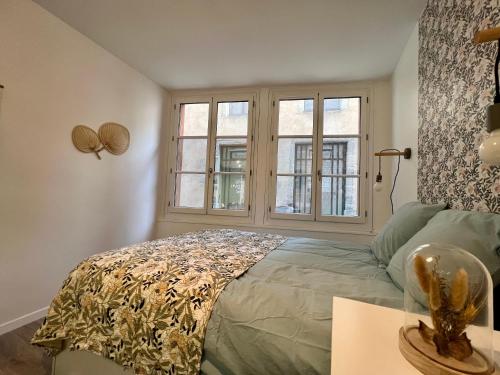 a bedroom with a bed and a window at L'Oliveraie in Brioude