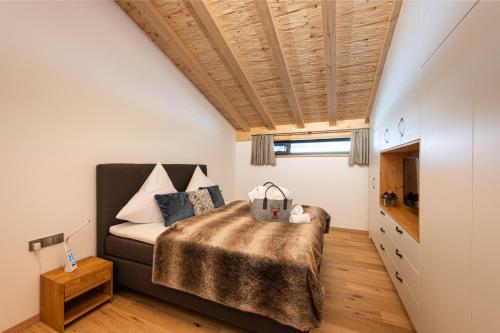 a bedroom with a bed and a wooden ceiling at Alpine Lifestyle Lodge in Oberstdorf