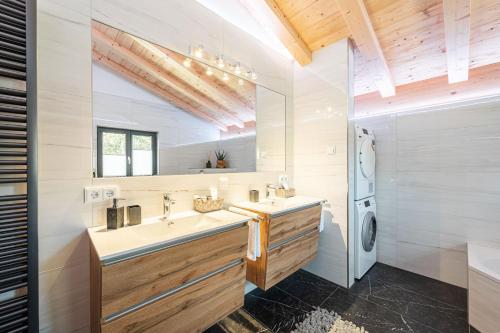 a bathroom with two sinks and a large mirror at Alpine Lifestyle Lodge in Oberstdorf