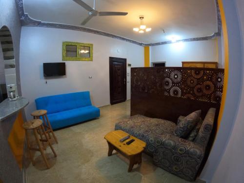 Cozy Apartment Freedom في الغردقة: غرفة معيشة مع أريكة زرقاء وطاولة