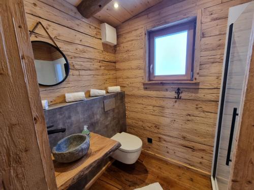 a wooden bathroom with a sink and a toilet at Chaleny - Das erste Tiny House Chalet im Zillertal in Hainzenberg