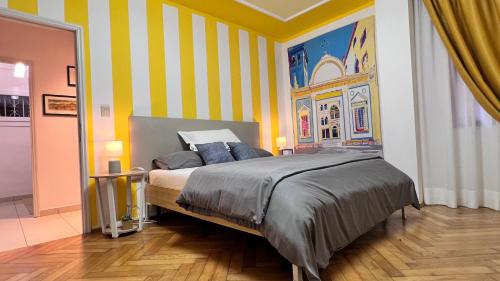 a bedroom with a bed and a striped wall at Behind On The Canalside Venice in Venice