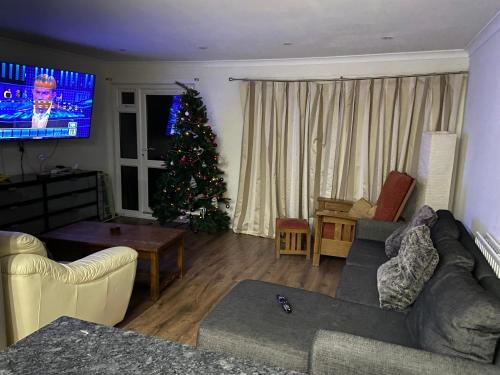 a living room with a christmas tree and a couch at Fully equipped Large 3 bedroom in Bishops Stortford