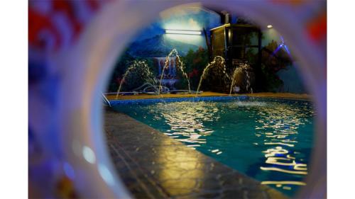 een glazen raam met uitzicht op een zwembad bij شاليهات دي لا كروز in Mekka