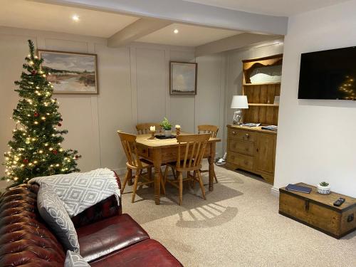 a living room with a christmas tree and a table at Grade II Listed 2 Bed Cottage with Free Parking in King's Lynn