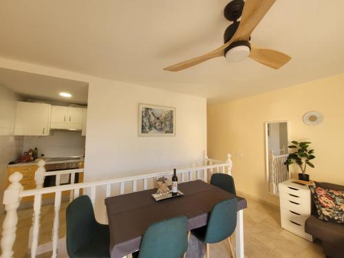 a dining room with a table and chairs and a ceiling fan at Apartament CALETA in Caleta De Fuste