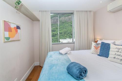 1 dormitorio con 1 cama blanca grande y ventana en Urca Design - Luxo, Garagem, Piscina, en Río de Janeiro
