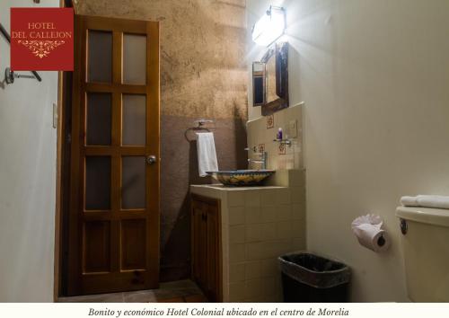 baño con lavabo, aseo y puerta en Hotel Morelia Callejón en Morelia