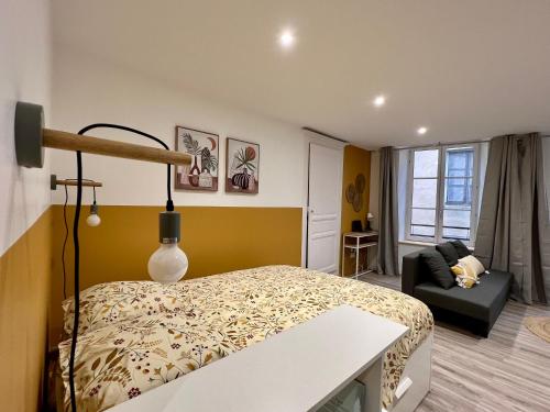 1 dormitorio con 1 cama y 1 sofá en una habitación en La Palmeraie, en Brioude