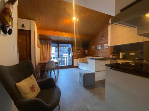 - une cuisine avec un canapé et une chaise dans la chambre dans l'établissement Appartement chaleureux près du domaine skiable du Linga, Multi Pass été à 3€/jour/personne - FR-1-693-18, à Châtel