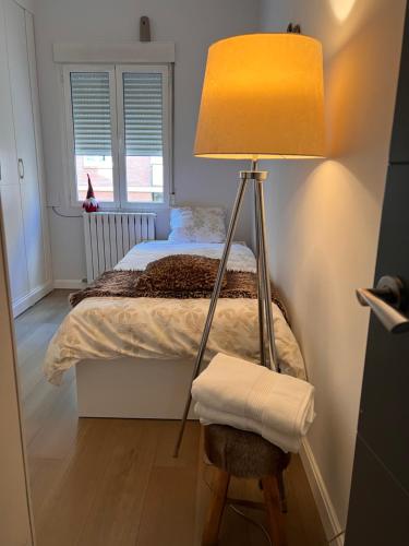 a bedroom with a bed with a lamp and a chair at Piso en el centro, Lujos a tu alcance, NYC in Zaragoza