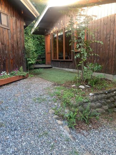 a house with a garden in front of it at Cabañas Koyam Ruka in Licán Ray