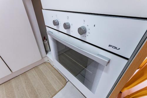 a white oven with a glass door in a kitchen at San Carlos rentals - Lastarria in Santiago