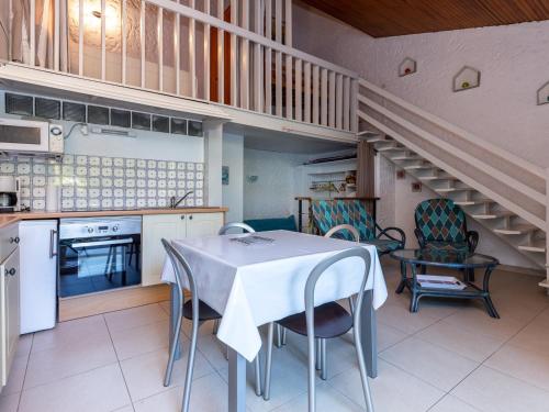une cuisine avec une table et des chaises ainsi qu'un escalier dans l'établissement Studio duplex sous la pinède près de la plage, terrasse, au calme et proche des activités, Seignosse - FR-1-239-394, à Seignosse