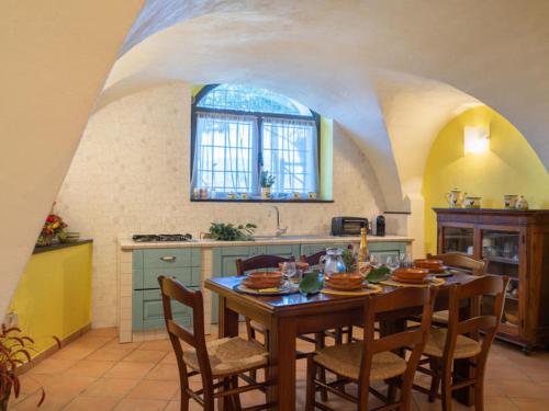 - une cuisine avec une table et des chaises en bois dans la chambre dans l'établissement Agriturismo IL POGGIO DI VASIA CITR00864-AGR-0001, à Vasia