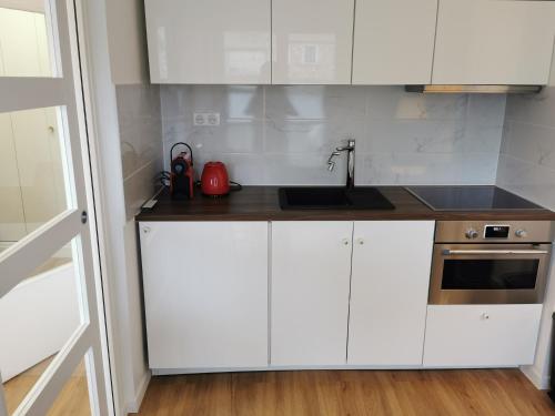 une cuisine avec des armoires blanches et un évier dans l'établissement 1min BusStop to St Germain En Laye - Chambourcy Center - Wei&Pei Apartment, à Chambourcy