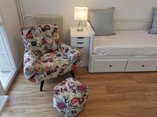 a bedroom with a chair next to a bed at Charming apartment Chambourcy in Chambourcy